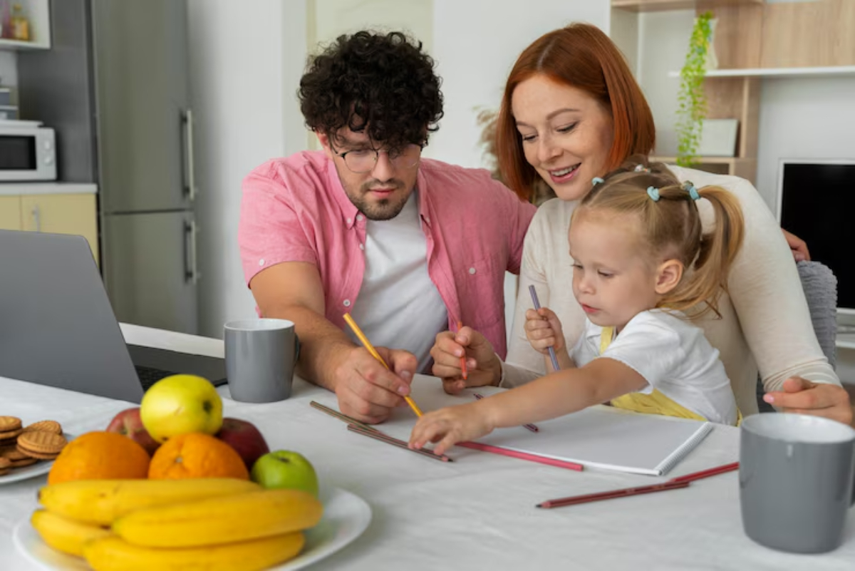 A family engages in a creative activity, drawing with colored pencils at a table filled with fruits and snacks.